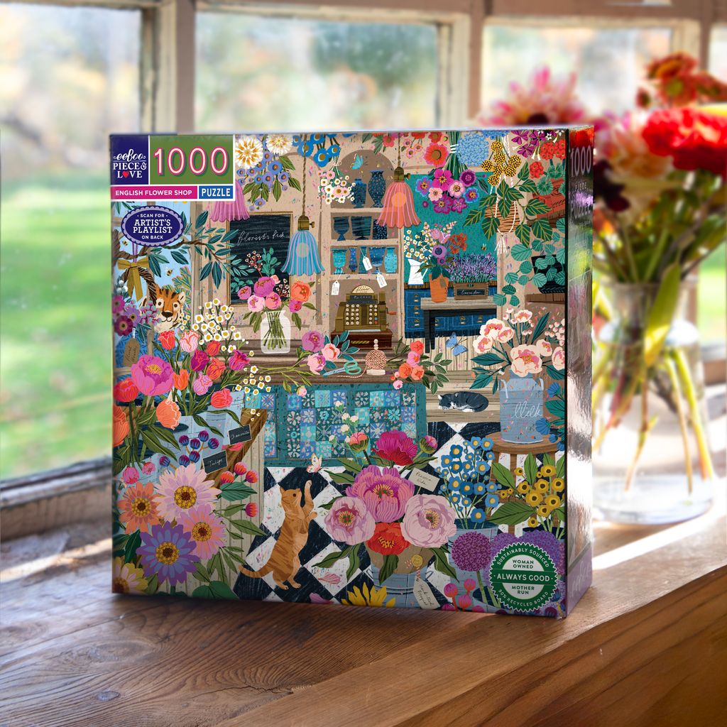 Jigsaw puzzle box with floral and interior design theme on a wooden surface.
